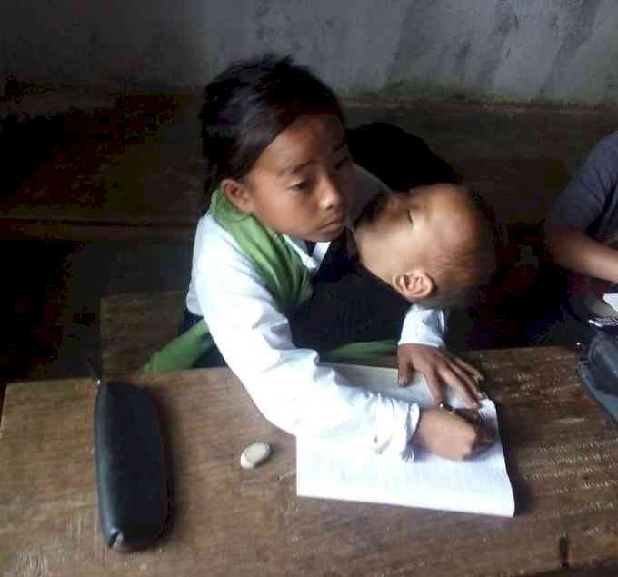 Manipur: 10-yr-old girl attends classes with sister in lap