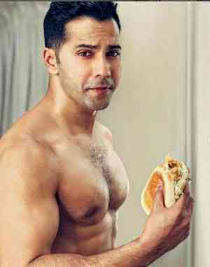 Varun Dhawan chomps on burgers, flaunts his abs on 'cheat day'