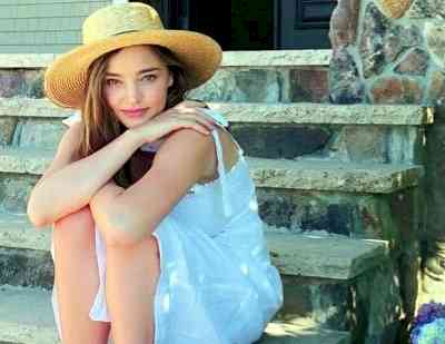 Miranda Kerr flaunts baby bump in festive dress